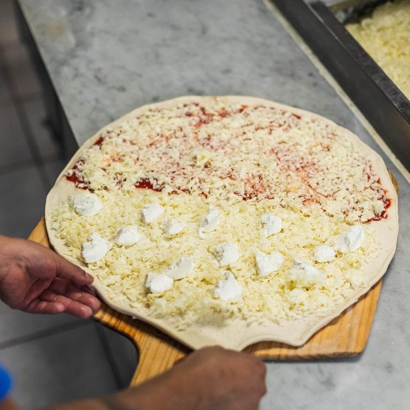 Pizza being prepared in the kitchen